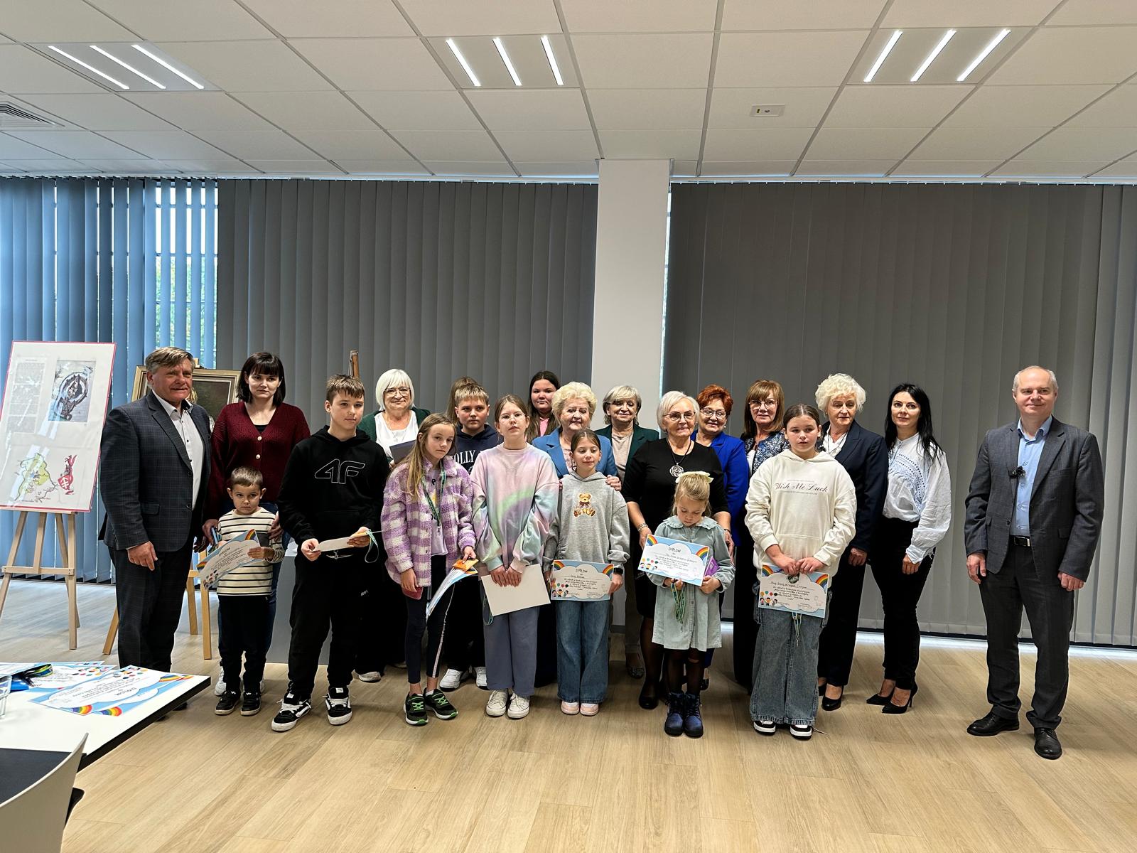 Wspólne zdjęcie dzieci, seniorów i organizatorów z dyplomami po zakończeniu konkursu