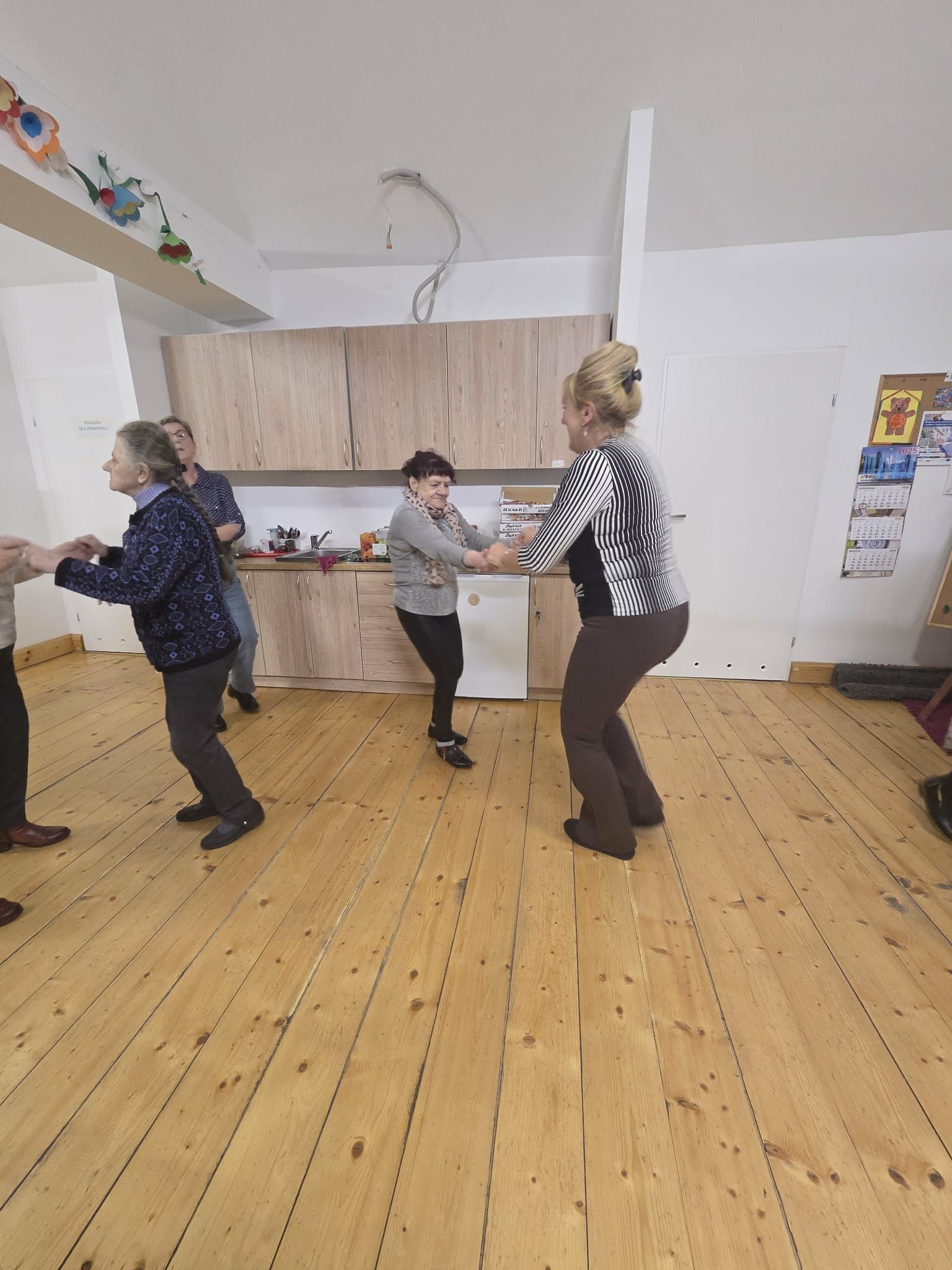 Seniorzy i młodzież tańczący razem na parkiecie